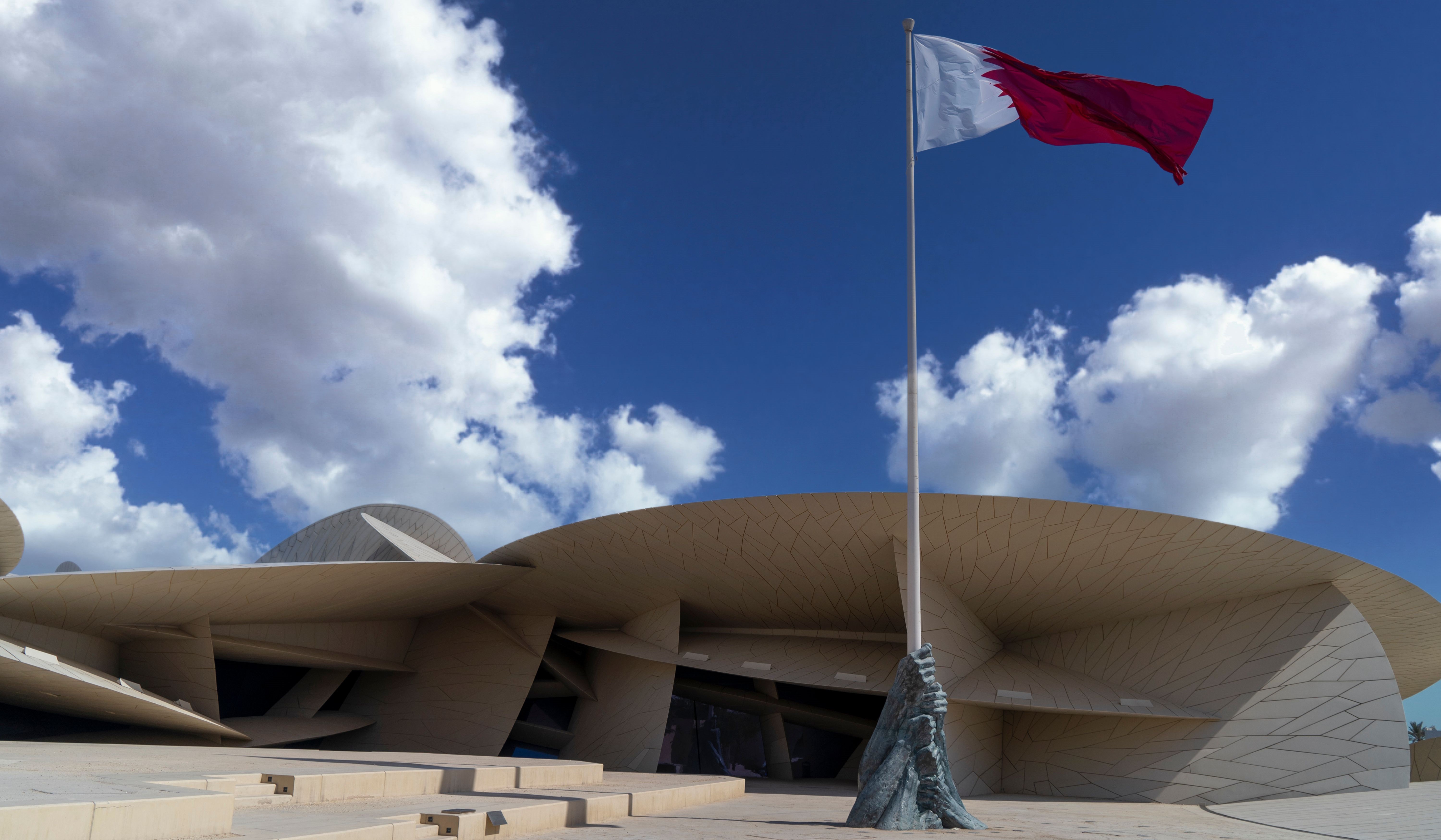 Qatar flag flying above the National Museum desert rose domes